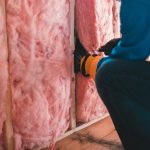 close-up of a man insulating a wall