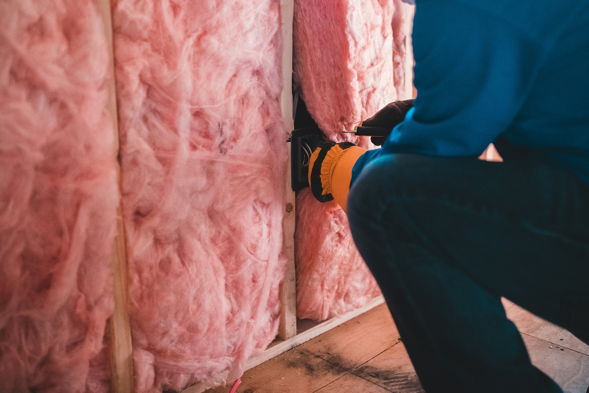 close-up of a man insulating a wall